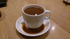 A white cup of coffee on a saucer