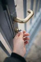 A hand inserting a key into a door lock