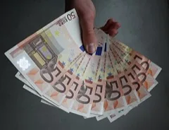 A hand holding a fan of 50-euro banknotes