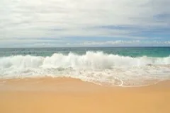 A sandy beach with waves rolling in