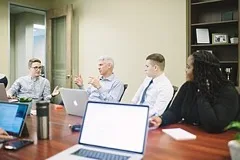 A group of colleagues discussing around an office meeting table